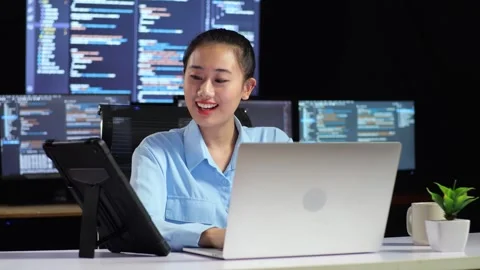 Female Programmer Looking At Tablet And Writing Code Laptop Multiple Monitors Stock Footage 244421111
