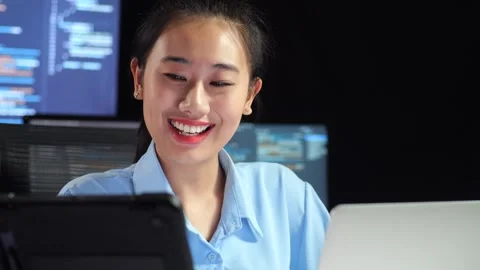 Female Programmer Looking At Tablet And Writing Code Laptop Multiple Monitors Stock Footage 244422234