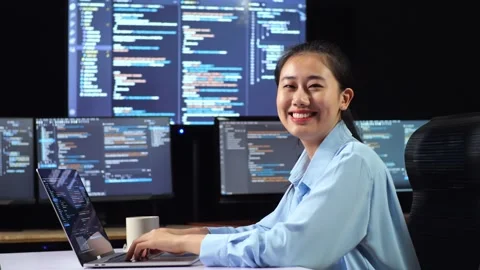 Female Programmer Smiling To Camera  Writing Code Laptop Using Multiple Monitors Video stock 244427117