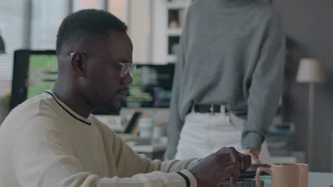 Female Programmer Talking with Black Male Colleague in Office Stock Footage 259149238