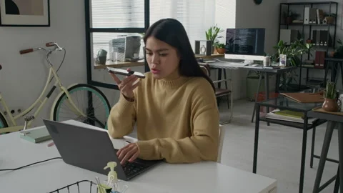 Female Programmer Talking on Phone and Typing on Laptop during Workday Stock-Footage 299347804