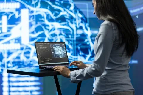 Female programmer using AI neural network on laptop Stock Photos