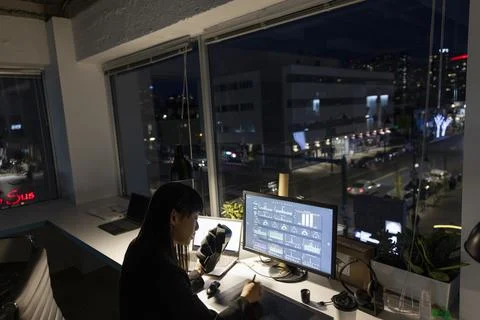 Female programmer with VR headset working late at computer in office Stock Photos