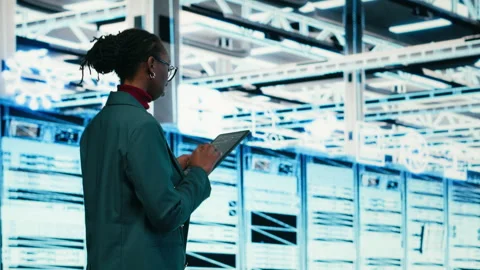 Female programmer walking in data center using tablet to write code Stock-Footage 329718980