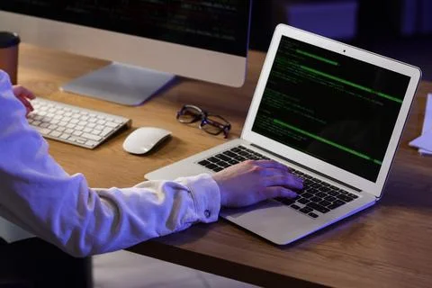 Female programmer working with computer and laptop in office at night Stock Photos