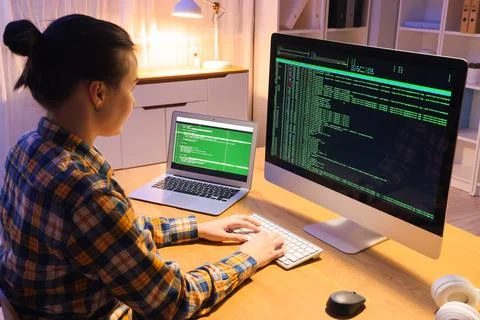 Female programmer working with computer in office at night 스톡 사진