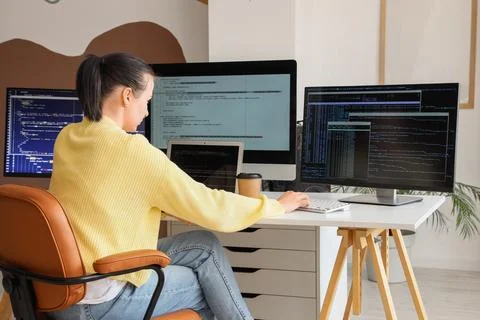 Female programmer working at desk in office, back view Stock Photos