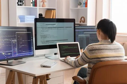 Female programmer working at desk in office, back view Stock Photos