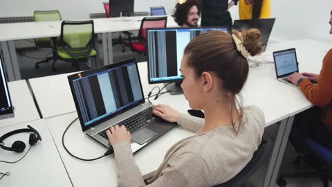 Female programmer working on desktop computer at white desk in office Stock Footage 166587853