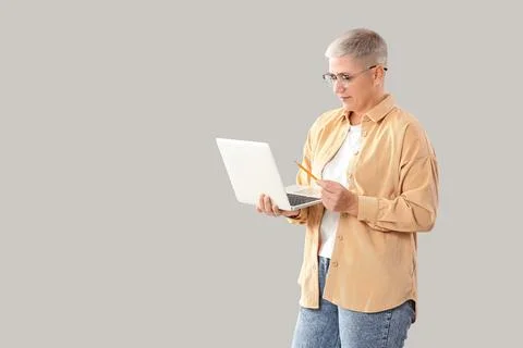 Female programmer working with laptop on light background Stock Photos