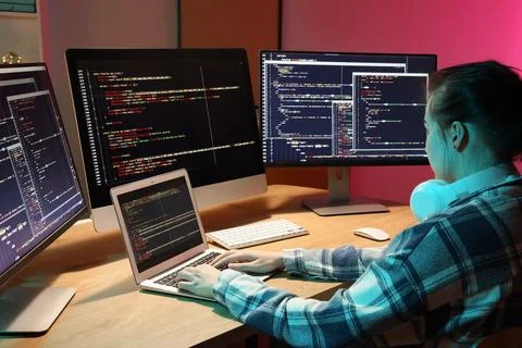 Female programmer working with laptop in office at night Stock-Fotos