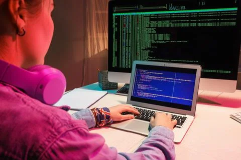 Female programmer working with laptop in office at night Stock-Fotos