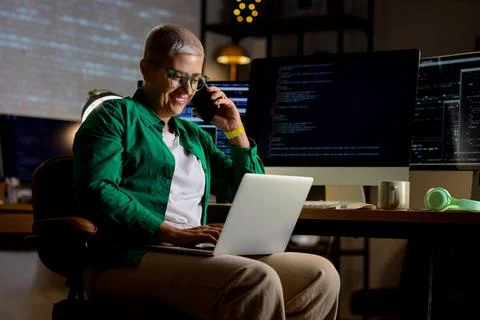 Female programmer working with laptop in office at night Stock-Fotos
