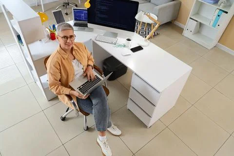 Female programmer working with laptop in office, top view Stock Photos