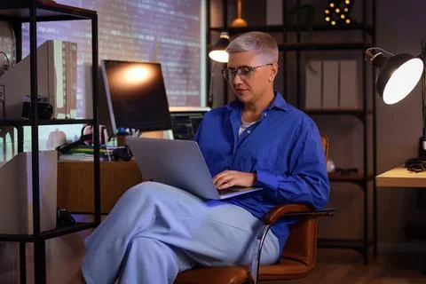 Female programmer working with laptop in office at night Stock Photos
