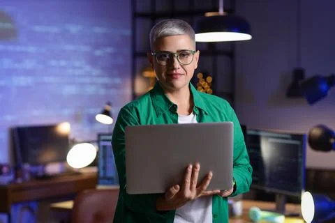 Female programmer working with laptop in office at night Stock Photos
