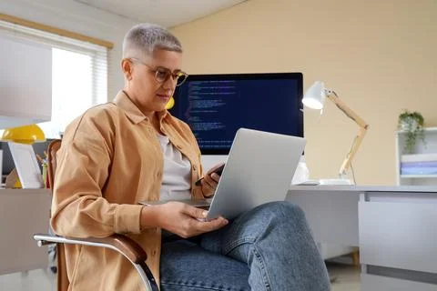 Female programmer working with laptop in office Stock Photos