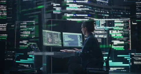 Female Programmer Writing Code Surrounded by Big Screens Stock Footage 243285877