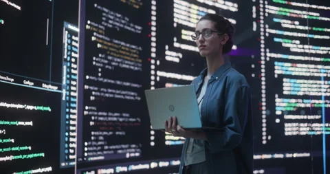 Female Programmer Writing Code Surrounded by Big Screens Video stock 243288693