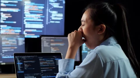 Female Programmer Yawning Sleeping Writing Code   Laptop Using Multiple Monitors Stock Footage 244426247
