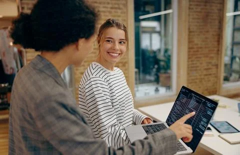 Female programmers enjoying time with laptop and distance job while standing at Stock Photos