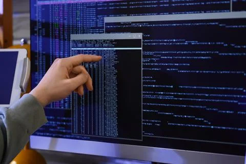 Female programmer's hand testing code on computer in office at night, closeup Foto stock