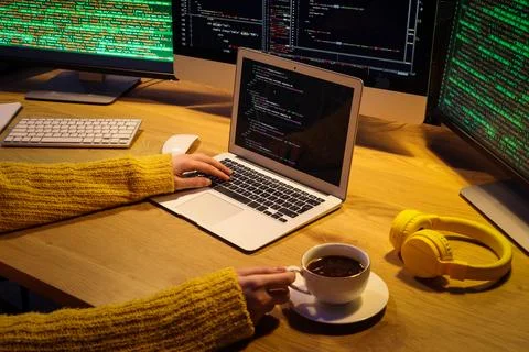 Female programmer's hands with cup of coffee working in office at night Stock Photos