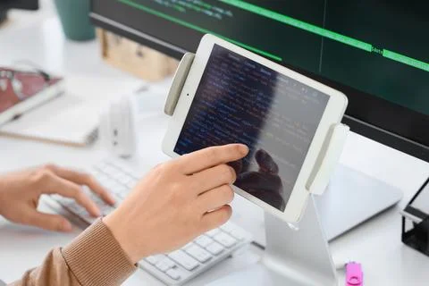 Female programmer's hands testing code on tablet computer in office, closeup Foto stock