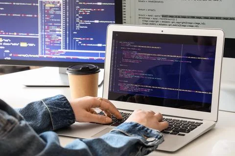Female programmer's hands working with laptop at desk in office, closeup Stock Photos
