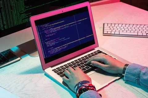 Female programmer's hands working with laptop in office at night, closeup Stock-Fotos