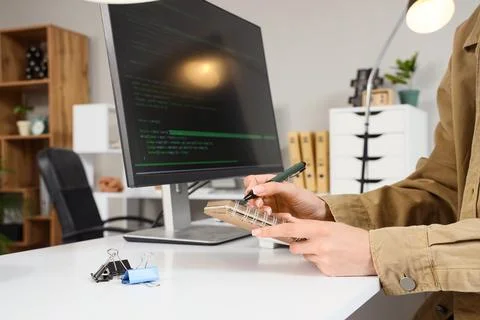 Female programmers hands writing in notebook at office 스톡 사진