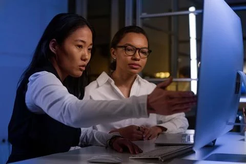 Female Programmers Working In Evening Stock-Fotos