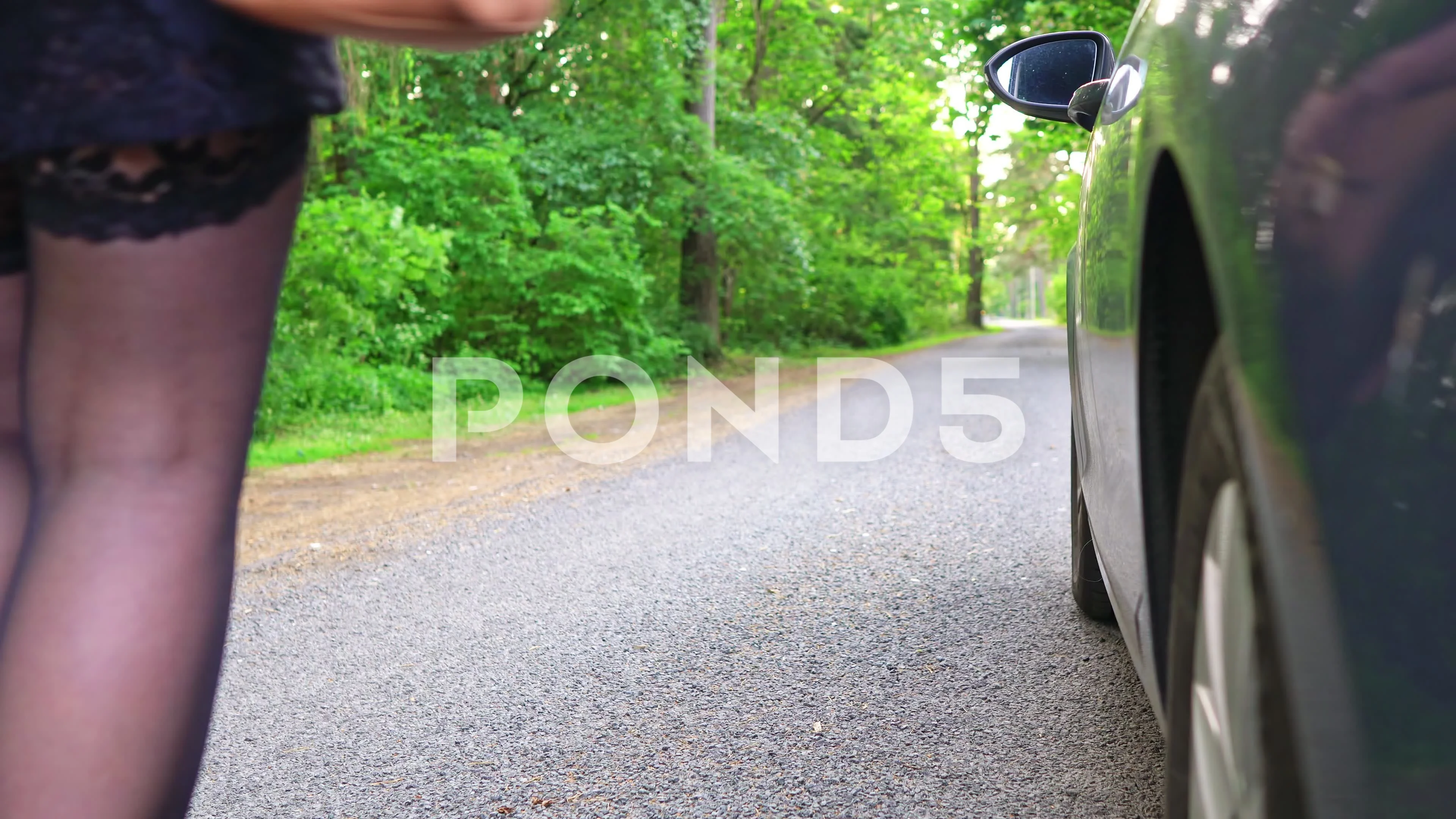 Female prostitute flirting near the client’s car.