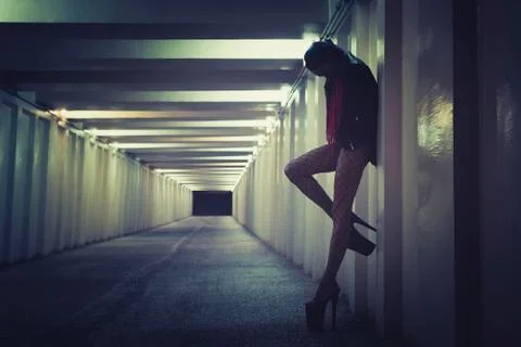 Female prostitute working on the night street. sexy girl stands at the wall i Stock Photos
