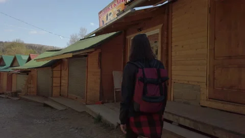 Female in protective neoprene face mask walking at empty street in small town Stock Footage 130503553