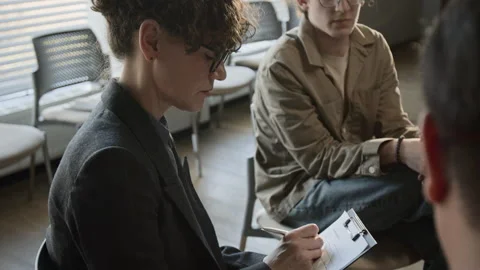 Female Psychotherapist Taking Notes in Group Therapy Session Stock Footage 337242032