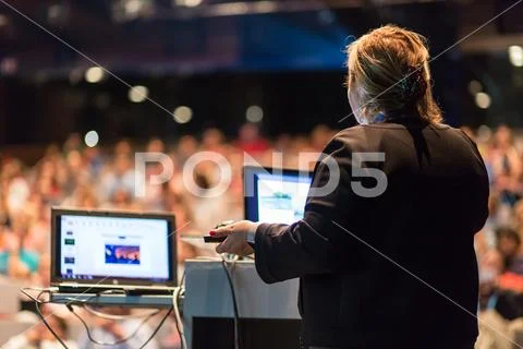 Female public speaker giving talk at Business Event. Stock Photos