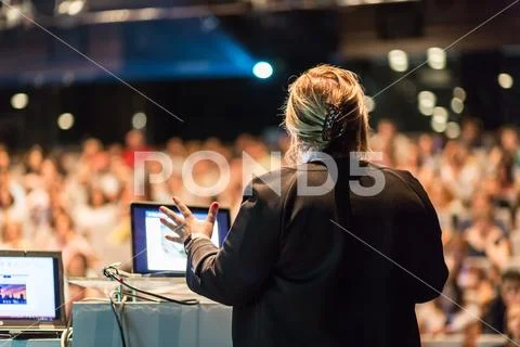 Female public speaker giving talk at Business Event. Stock Photos