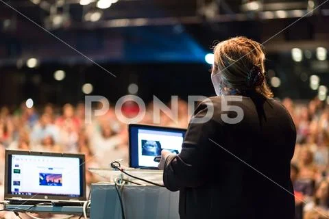 Female public speaker giving talk at Business Event. Stock Photos