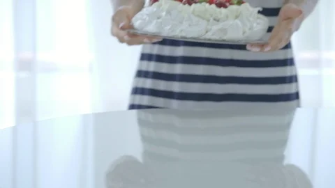 Female puting white cake with berries at the table. Pavlov s dessert Stock Footage 92377072