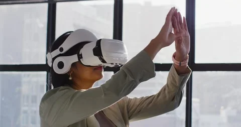 Female putting on white VR headset, raising and testing controls at office Video stock 345839906