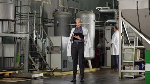 Female quality control expert making notes in report in factory Stock Footage 127707616