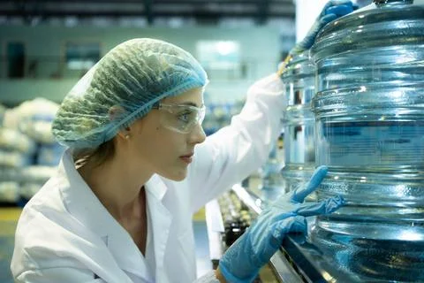 Female quality control workers in a drinking water factory Inspecting the ... Stock Photos