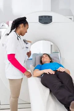 Female Radiologist Looking At Patient Undergoing MRI Scan Foto stock