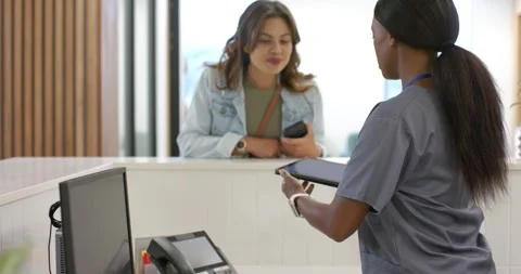 Female receptionist presenting tablet after visitor arriving and leaning on Stock Footage 344254065