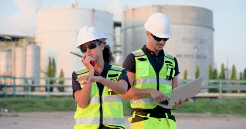 Female refinery technician reporting operational update through walkietalkie Stock Footage 341476968