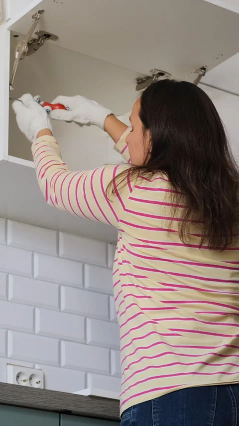 Female renovating by assembling kitchen set Stock Footage 318274223