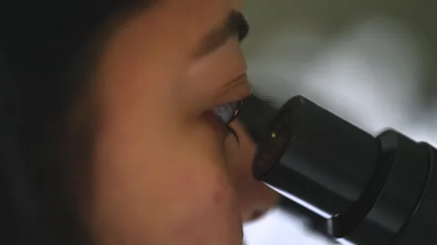 Female research scientist looking at samples under microscope Stock Footage 250419649