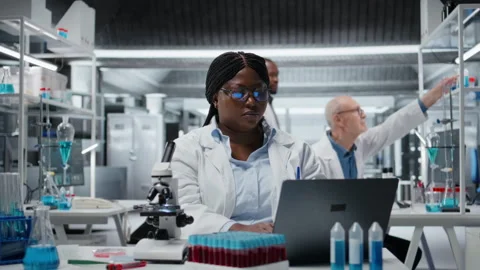 Female researcher brainstorms in laboratory, using laptop software Stock Footage 326013079