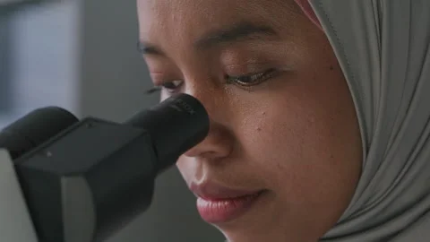 Female Researcher in Hijab Using Microscope in Scientific Laboratory Stock Footage 312473428